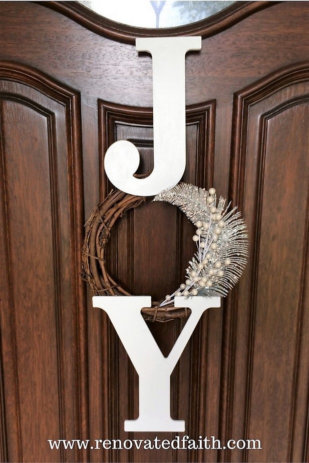 JOY Christmas Wreath – Whether you are decorating your front door or mantel for the Holidays, this JOY wreath is easy to customize with deco mesh or you can keep it simple with red berries, pine cones or ribbon. This tutorial shows you how to make this cute Christmas wreath and it works well as a Christmas craft night project. #easydiy #easycrafts #renovatedfaith #Christmas #craftnight #berries #wreath #christmaswreath