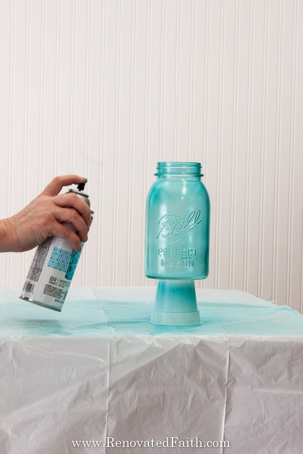 spraying a mason jar blue