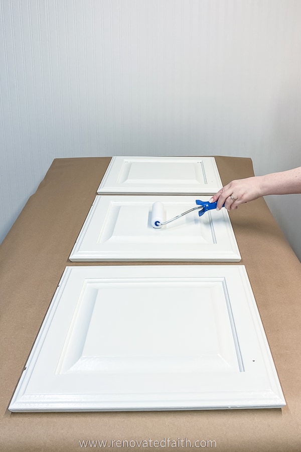 rolling paint on three cabinet doors in white