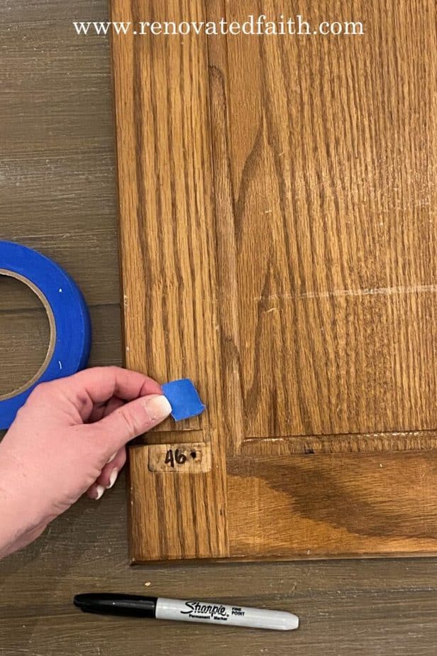 labeling cabinet doors with number and applying tape on top