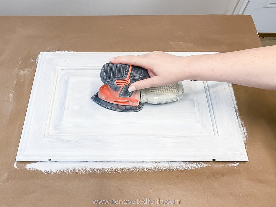 woman's hand sanding cabinet door