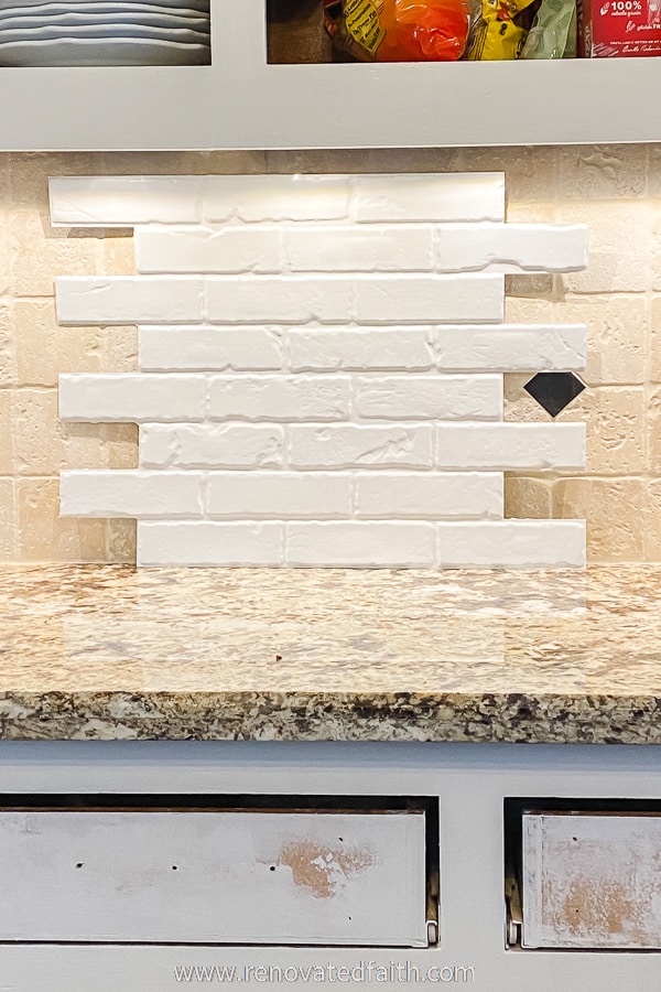white brick packsplash panel over old tile