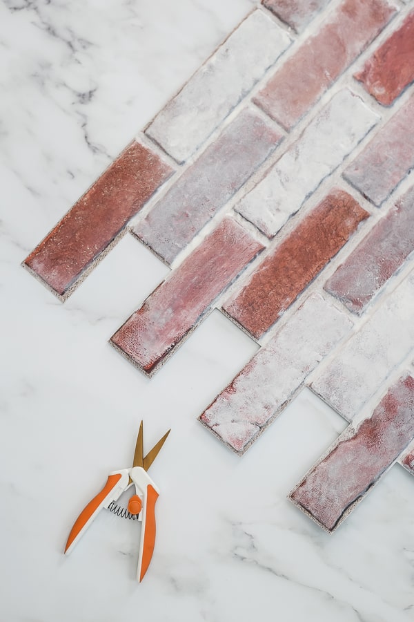 whitewashed brick faux backsplash panel and scissors