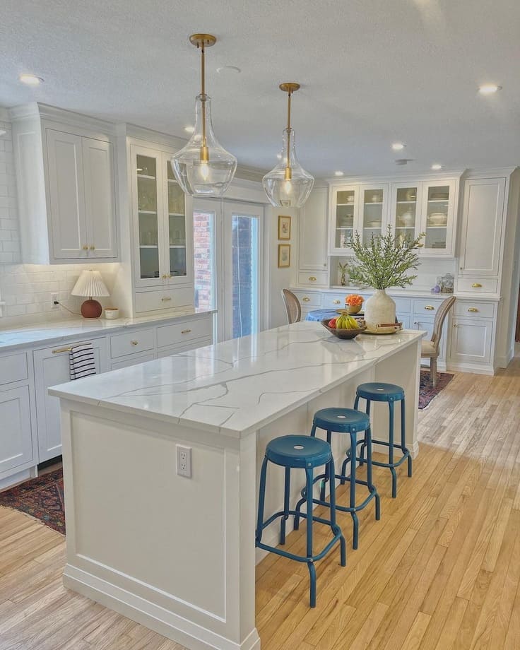 kitchen with simply white cabinets and blue bar stools