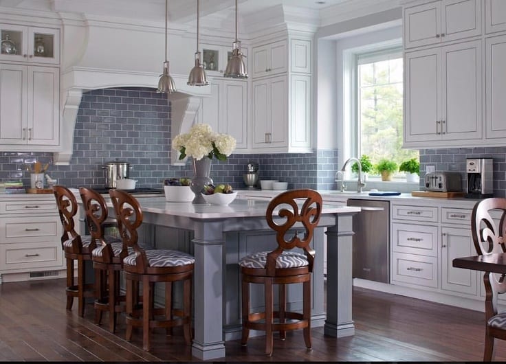 tranditional kitchen with gray island and white cabinets