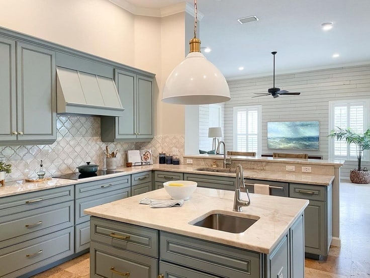 kitchen with blue gray cabinet paint and neutral counters and backsplash