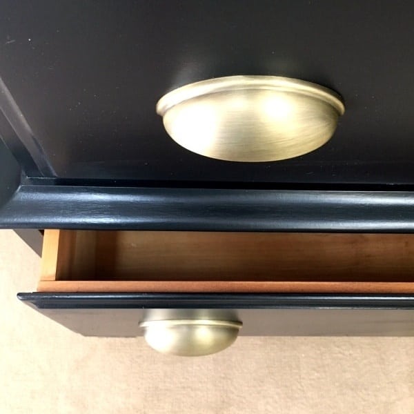 close up of black dresser with gold pulls