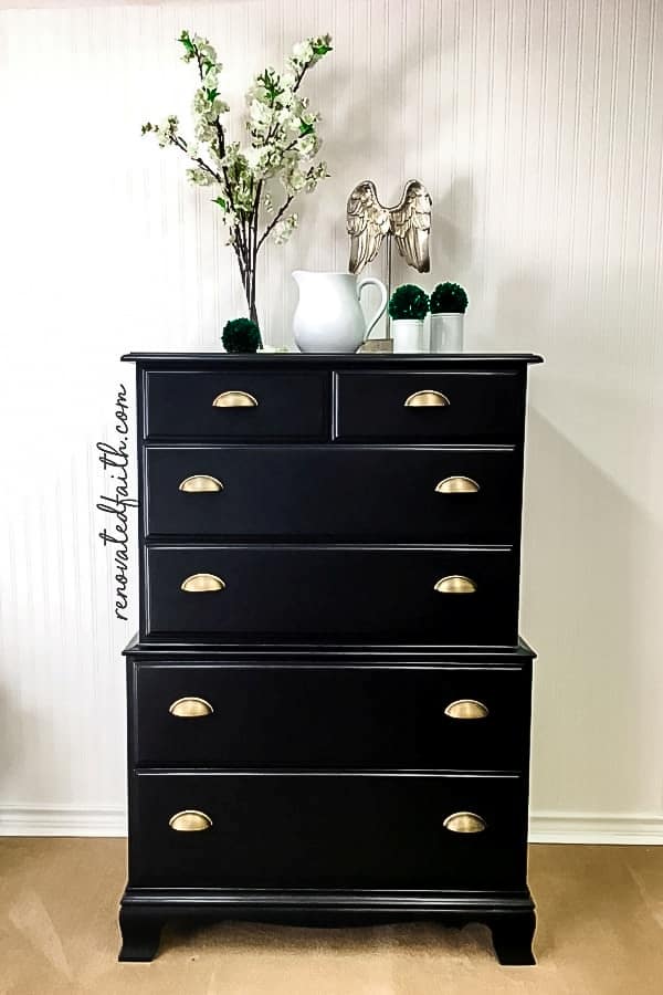 black dresser with white flowers on top