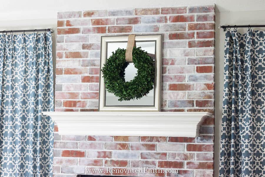 whitewashed fireplace with wreath